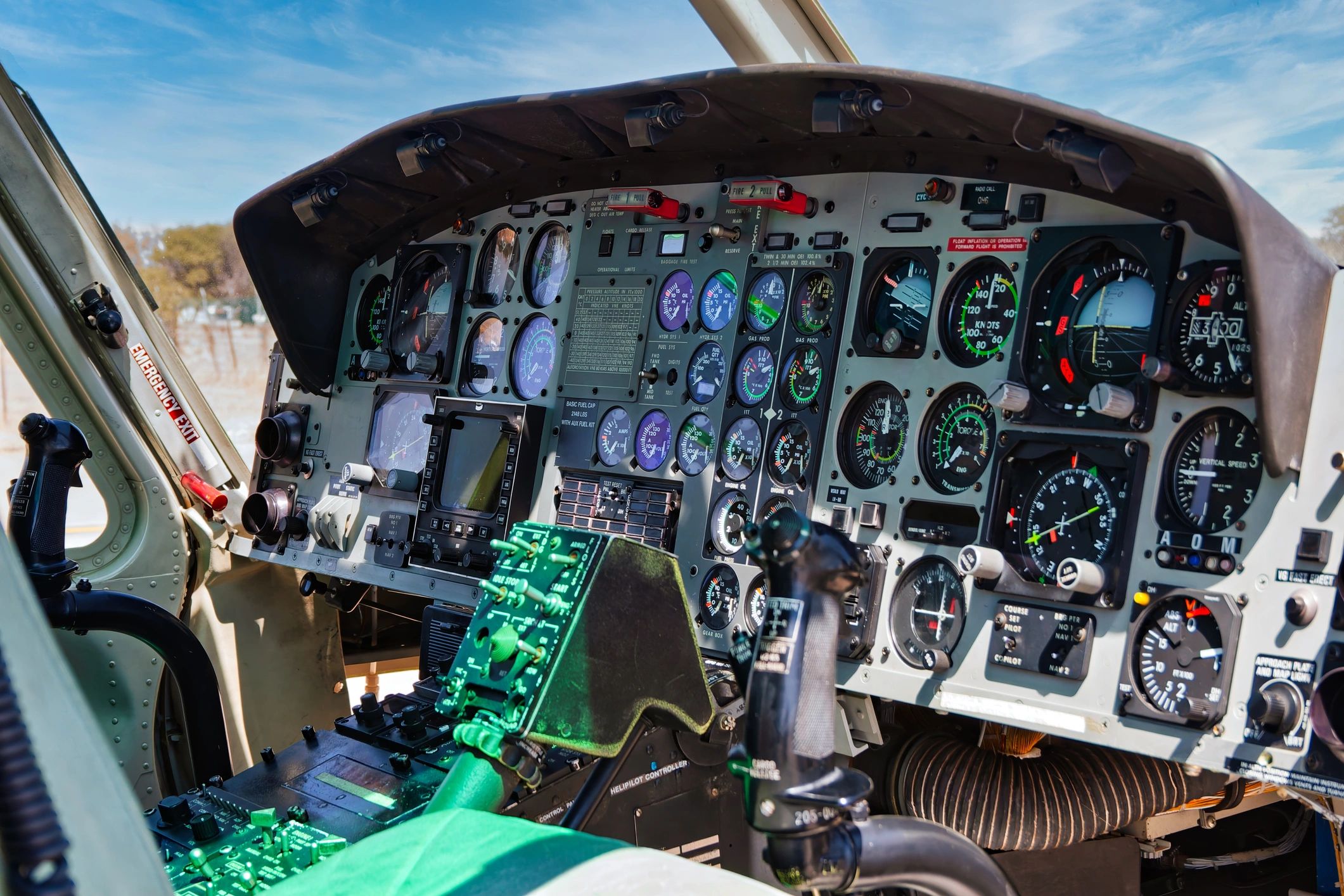 Interior view of a helicopter cockpit with analog flight instruments and controls